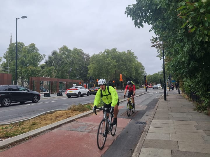Cyclists using the new cycle lane, even though surfacing still patchy.