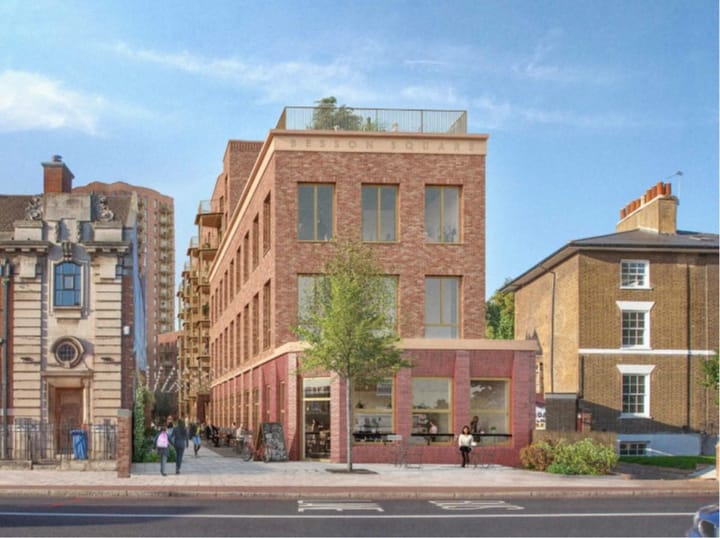 View of revised scheme from New Cross Road, brick facade building, with tower visible in background. 