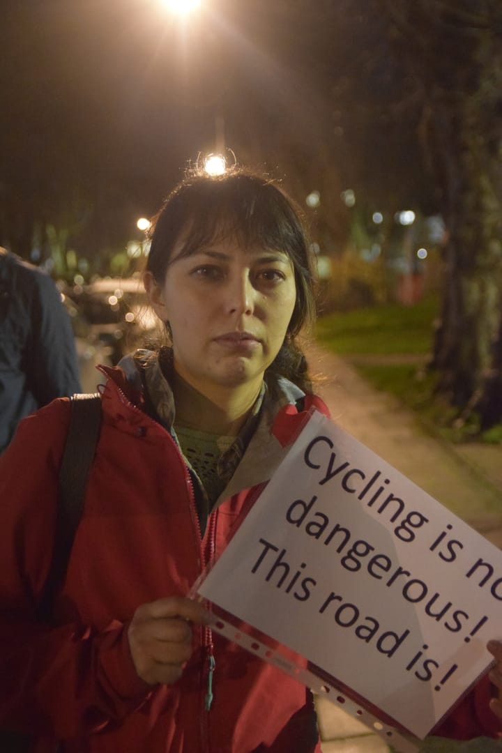 Emily Finch, New Cross Gate resident and cyclist, holding sign ' cycling is not dangerous, this road is!'